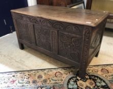 A 17th Century oak coffer, the later top over a lunette carved frieze and three carved panels,