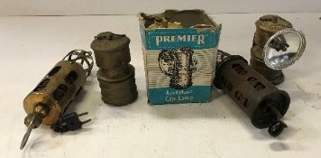 Three Premier Acetylene Cape lamps, one with cardboard box, together with a brass J.