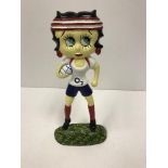 A modern painted cast iron figure of Betty Boo carrying a rugby ball,