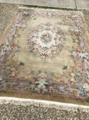 A Chinese superwash rug with central floral cream ground medallion on a gold ground,