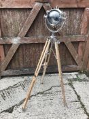 A modern spotlight type floor lamp with teak tripod stand