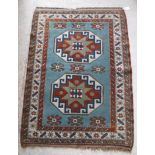 A Persian rug with two repeating elephant foot medallions on a turquoise ground within a brown,