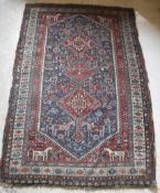 A fine Qashqai tribal rug with three repeating lozenge medallions on a dark blue ground decorated