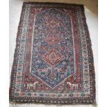 A fine Qashqai tribal rug with three repeating lozenge medallions on a dark blue ground decorated