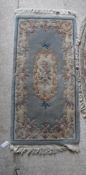 A Chinese superwash oval rug and another rectangular superwash rug,