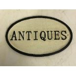 A modern painted cast metal sign "Antiques",