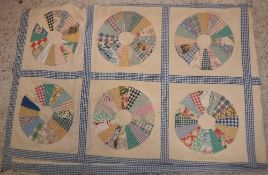 An early 20th Century patchwork quilt of panels of circular discs