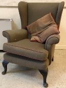 Two early to mid 20th Century upholstered wing back scroll arm chairs on cabriole legs to pad feet