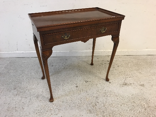 A reproduction burr walnut veneered silver table, the dished top over a fitted drawers,