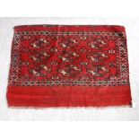 A Bokhara Juval rug with repeating medallion decoration on a scarlet ground,