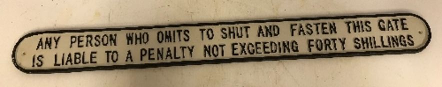 A modern painted cast iron sign inscribed "Any Person Who Omits To Shut and Fasten This Gate ....