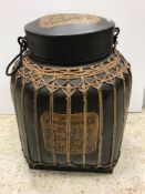 A modern Thai food container of caned form with black lacquered and script decorated panels,