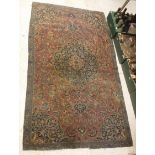 A Kashan rug, the central panel set with foliate decorated medallion on a red ground,