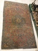 A Kashan rug, the central panel set with foliate decorated medallion on a red ground,