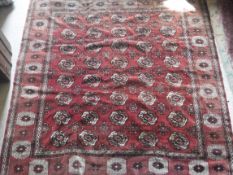 A Bokhara carpet with all over elephant foot medallion decoration on a red ground,