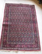 A fine Persian rug with all over leaf decoration on a red ground,