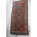 A Caucasian rug with repeating lozenge medallions in green, terracotta and blue,