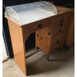 An early 20th Century stained pine watchmaker's cabinet with perspex domed compartment over a