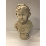 An early 20th Century painted plaster bust of a young girl with bow in her hair,