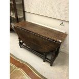 A late 17th Century oak oval gate-leg drop-leaf dining table on baluster turned and ringed supports