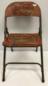 A painted metal folding chair inscribed "1985 Coca Cola New Coke"