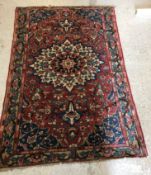 A Caucasian rug with central flower decorated star burst centre medallion on a floral decorated red