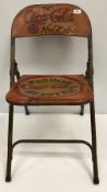 A painted metal folding chair inscribed