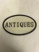 A modern painted cast metal sign "Antiques",