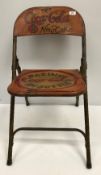 A painted metal folding chair inscribed