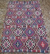 A caucasian tribal kelim with five bands of lozenge medallions in dark brown, blue, red and cream,