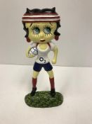 A modern painted cast iron figure of Betty Boo carrying a rugby ball,