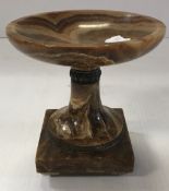 A brown onyx urn with silvered metal emb