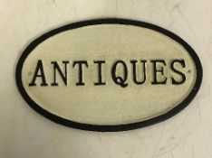 A modern painted cast metal sign "Antiques",