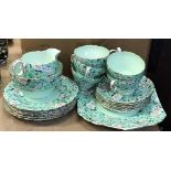 A Shelley "Marguerite" pattern green ground tea set with five cups and six saucers, six side plates,