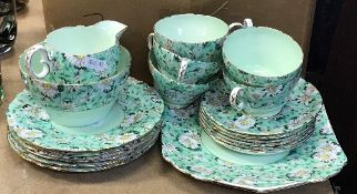 A Shelley "Marguerite" pattern green ground tea set with five cups and six saucers, six side plates,