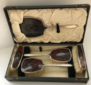 A George V silver and tortoiseshell mounted dressing table brush set comprising mirror,