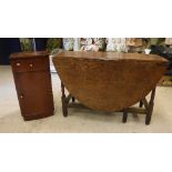 A 19th Century oak oval gate leg drop leaf dining table with two end drawers on turned supports to