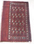 A Bokhara Juval rug with all over stylised medallion decoration on a red ground,