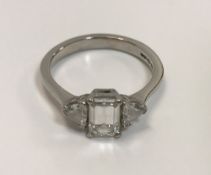 A platinum dress ring with central emerald cut diamond (approx 1.