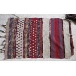 A Belouch tribal rug with repeating foliate medallions on a cream ground,