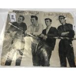 An unframed black and white photograph of The Shadows signed by all four members,