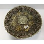 An Islamic copper, brass and white metal pedestal dish with high relief and medallion decoration,