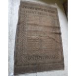 A Bokhara rug with central repeating rectangular medallions on a faded red ground within a