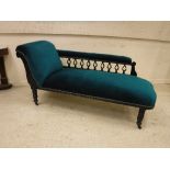 A Victorian ebonised framed and carved chaise longue with upholstered back rail and seat raised on