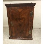 An early 18th Century walnut veneered hanging corner cupboard,