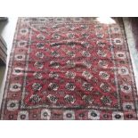 A Bokhara carpet with all over elephant foot medallion decoration on a red ground,