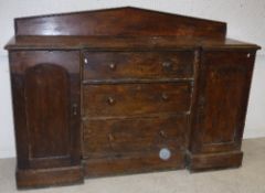 A Victorian stained pine break front sideboard with raised back over three central drawers flanked