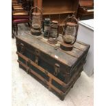 A vintage trunk and four hurricane lamps