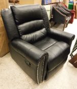 A modern black leather upholstered scroll arm reclining chair with studded decoration to the scroll