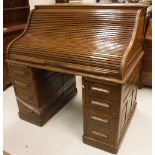 An early 20th Century oak tambour top desk,